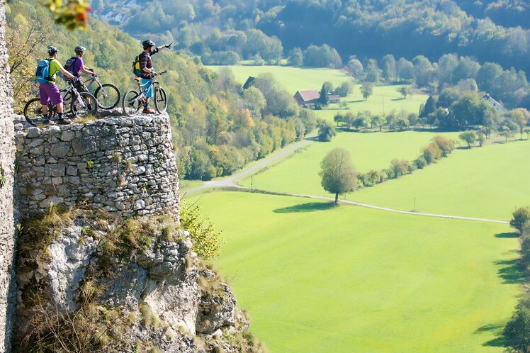 Eine Gruppe Mountainbiker die von einem Aussichtspunkt in die Fränkische Schweiz schauen | © Tourismuszentrale Fränkische Schweiz
